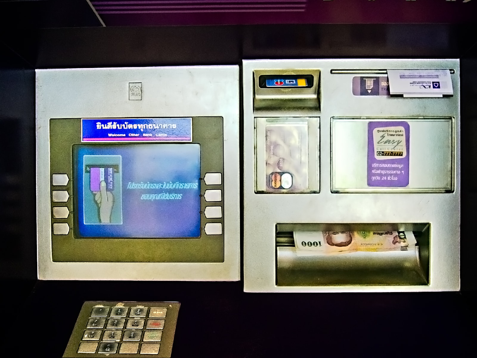 The front panel of a Siam Commercial Bank ATM in Thailand, with Thai-language on-screen prompts.